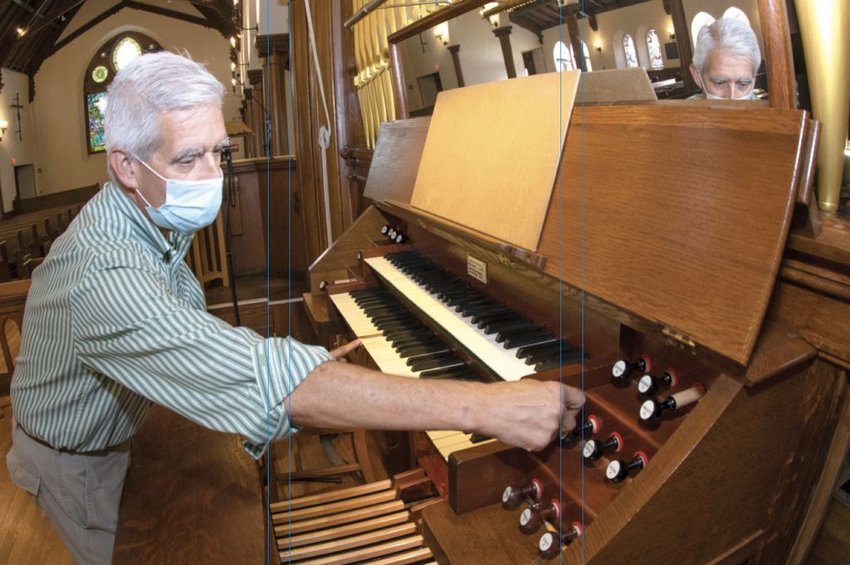Joe Hammer, director of music at St. Paul's Episcopal Church, works the levers and keys of the church's historic Hutchings-Votey 1902 pipe organ.