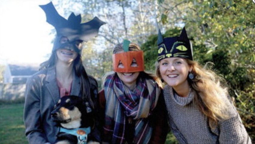 Cecilia, Maura, and Emily Wendelken with their dog Matilda, show off their cardboard masks and crowns.