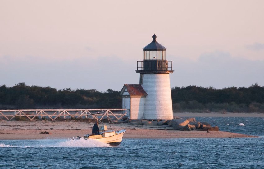 A scallop boat heads out to fish on the first day of commercial bay scallop season earlier this month, getting ready to round Brant Point Light.