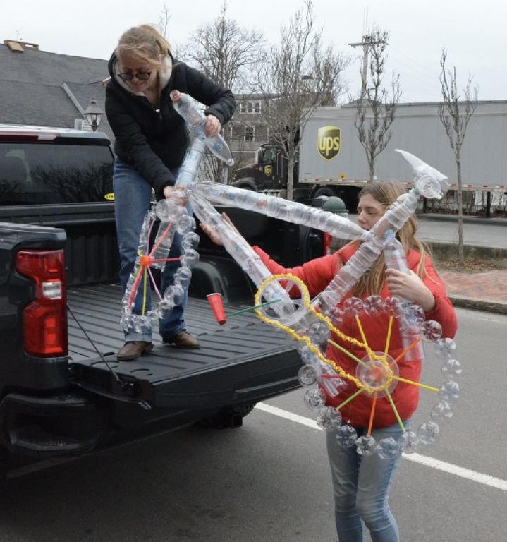 Phaedra Plank, on truck, and Tori Dixon unload the plastic bicycle sculpture created by the Nantucket High School art and environmental clubs.