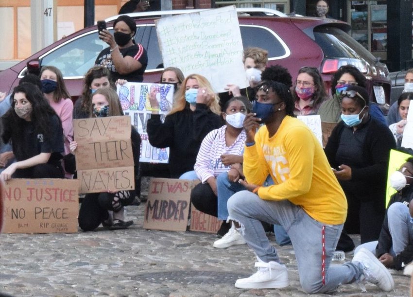 Islanders take a knee on Main Street as part of a peaceful protest on police brutality and racial inequity.