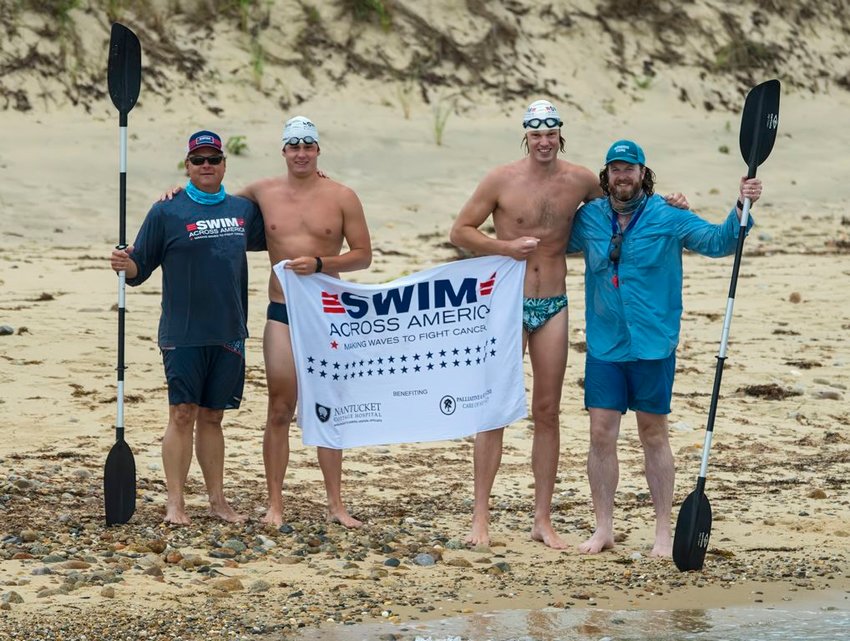 Tyler Roethke and Grant Wentworth hold a Swim Across America banner on Martha's Vineyard after swimming from Woods Hole Saturday. The duo raised more than $100,000 for the nonprofit.