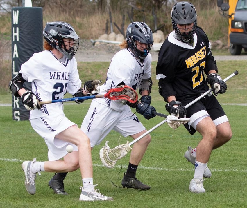 Sam O'Keefe and Spencer West check the stick of a Nauset defender in Nantucket's 16-4 win earlier this season.