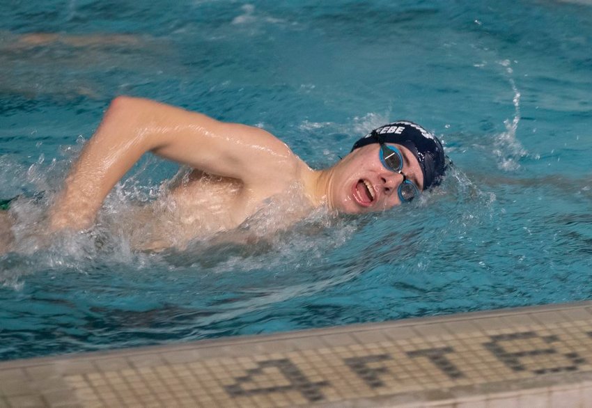 Grant Beebe warms up during varsity swimming practice Monday night.