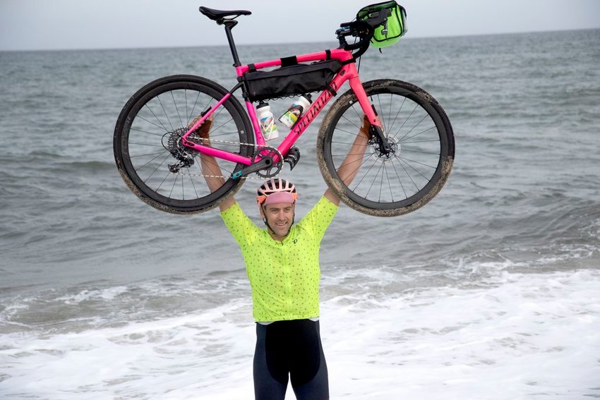 Ultra-athlete Rob Lea celebrates the completion of his &amp;#8220;Ultimate World Triathlon&amp;#8221; at Sconset Beach Monday. In addition to cycling across the country in 39 days, Lea also swam the English Channel and climbed Mt. Everest.