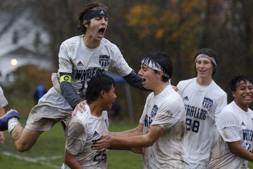 The boys varsity soccer team celebrates its 3-2 overtime win over top-seeded West Bridgewater Tuesday.