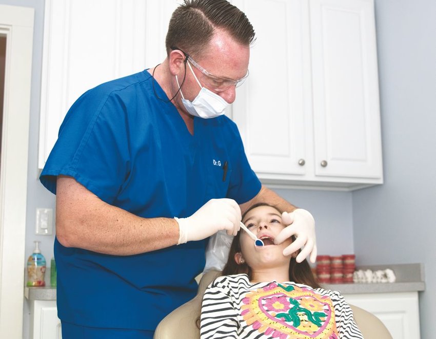 Dr. Brian Gaudreault of Southeast Orthodontics examines a patient at his Surfside Road office.