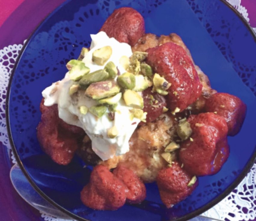Frozen strawberries poached in cardamom-scented orange juice are delicious when served over a scone with yogurt and pistachios.