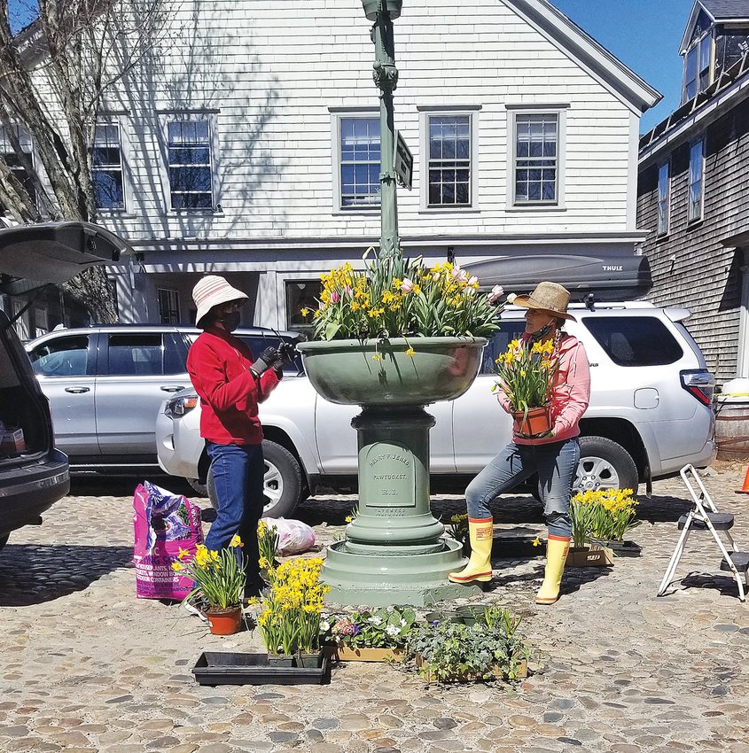 Heidi Drew, left, and Jill Sandole of the Nantucket Garden Club decorate the newly-installed Max Wagner Fountain on Main Street with fresh flowers Saturday.