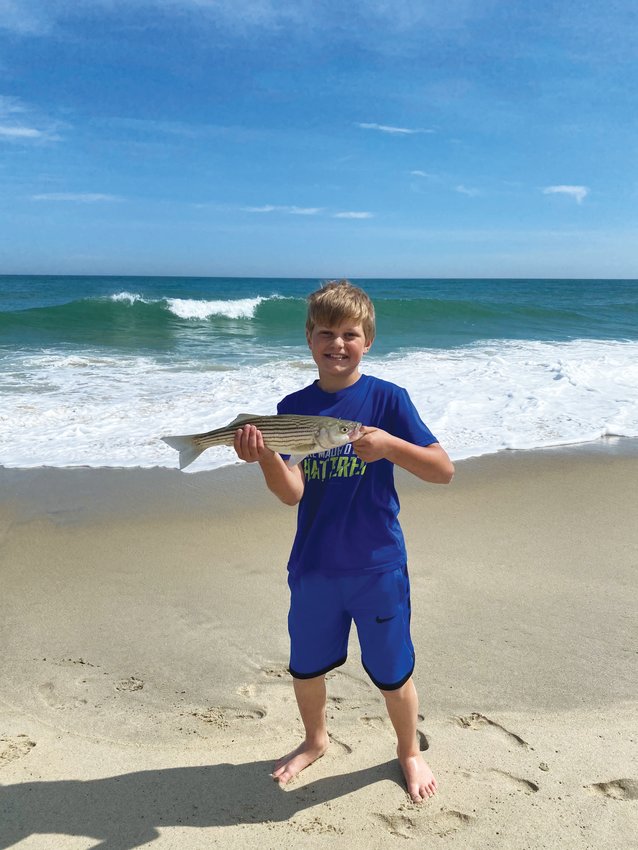 Nico Tedeschi, 13, with a small striped bass he caught this week.