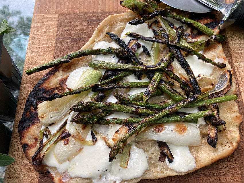 This grill-fired pizza is topped with mozzarella, grilled asparagus and grilled spring onions.