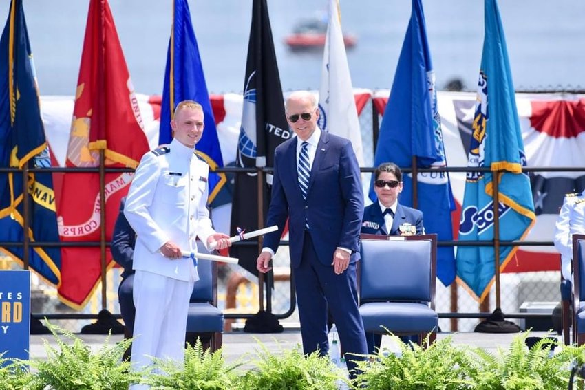 Jacob Aloisi receives his diploma and commission from President Joe Biden at the U.S. Coast Guard Academy.