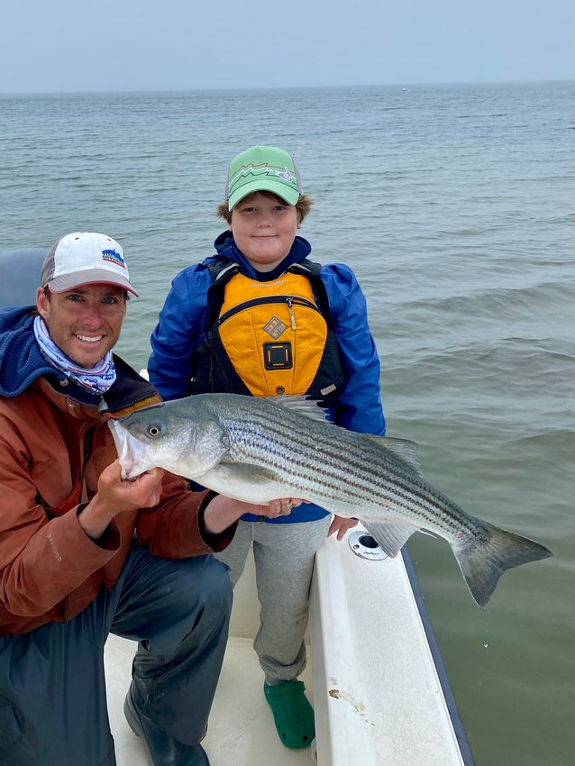 Corey Gammill and Alistair Wood with a striped bass they caught Monday.
