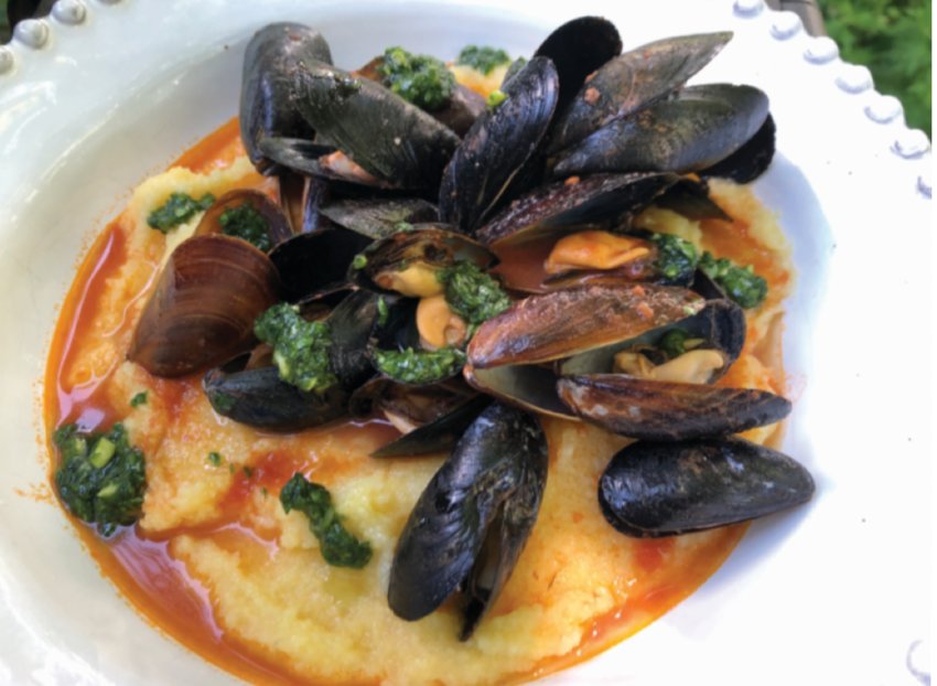 Mussels steamed in spicy tomato sauce with pesto over polenta.