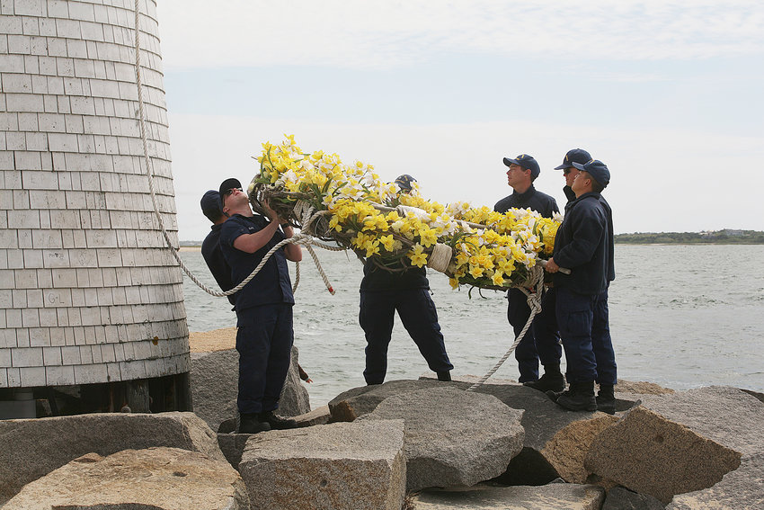 A crew from the US Coast Guard Station Brant Point takes down the daffodil wreath and puts up a flag in honor of Memorial Day and the Fourth of July at the Brant Point lighthouse.