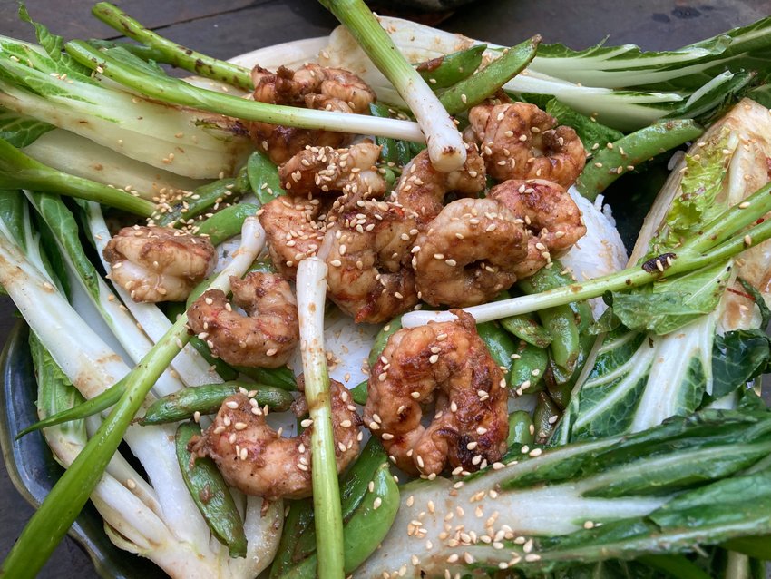 Grilled shrimp, bok choy, sugar snap peas and scallions can be served over rice or noodles for a hearty meal.