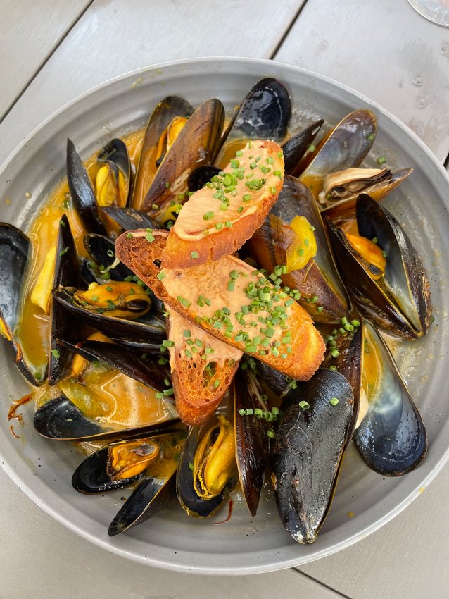 The steamed mussels are served in a light and lemony saffron broth.