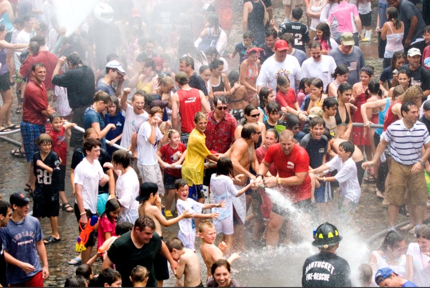 The Fourth of July water fight on Main Street is traditionally mobbed with people dousing each other and the Nantucket Fire Department on the slippery cobblestones.