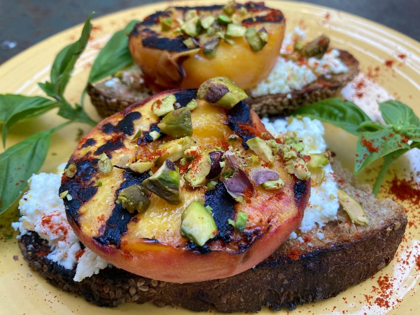 Open-faced grilled peach, ricotta and pistachio toasts.