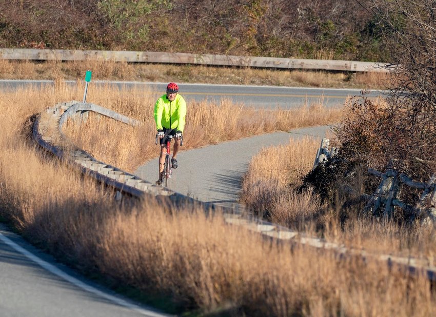 A cyclist rounds the bend on Polpis Road bike path near Sesachacha Pond Monday during a stretch of unseasonably warm weather.