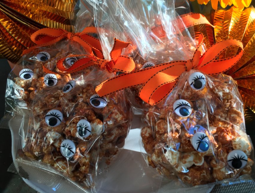 Homemade Cracker Jack packaged in clear bags with googly eyes and tied with orange ribbon is a true Halloween treat.
