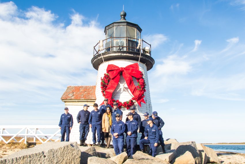 ALL DECKED OUT: The crew from U.S. Coast Guard Station Brant Point stands in front of Brant Point lighthouse after hanging the Christmas wreath &ndash; a tradition that goes back years.