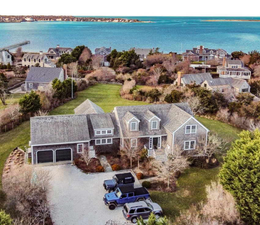 Located in the prestigious heart of Monomoy, just steps from Nantucket Harbor, this five-bedroom, four-and-a-half bathroom home has sweeping water views, meticulously-maintained lawns and gardens and deeded harbor access from a private beach.