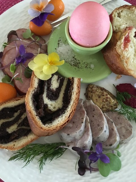 A plate of Easter brunch offerings with a Polish spin, including sweet and savory breads and kielbasa.