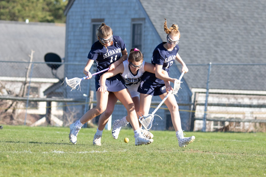 Hannah Evens attempts to squeeze her way through a pair of Cape Cod Academy defenders in last week&rsquo;s 18-11 win.