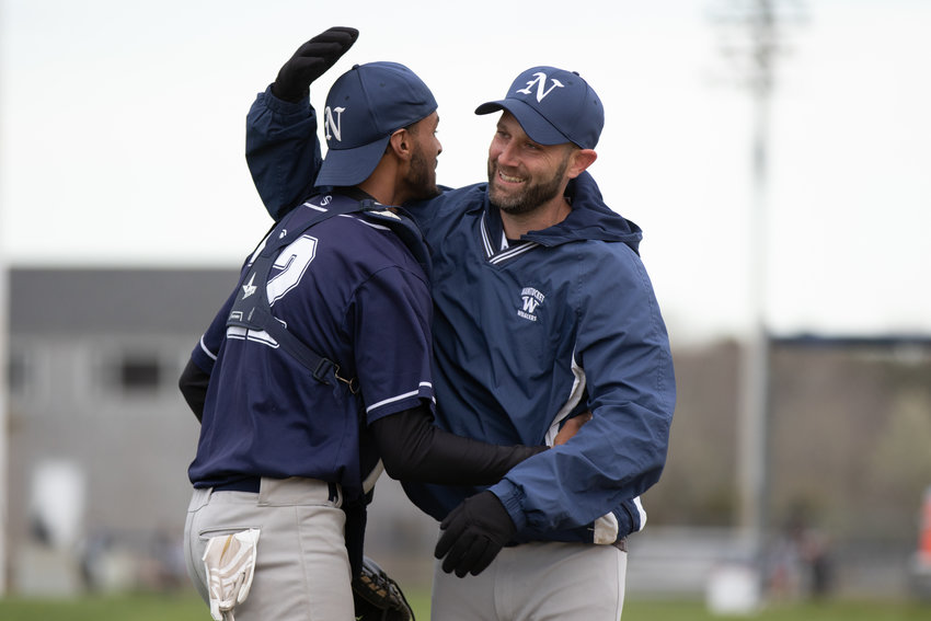 Catcher Argelis Nunez and coach Stefan Mandle embrace after the Whalers beat Rising Tide Friday.