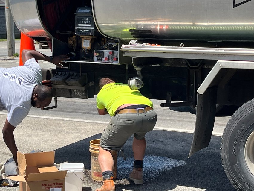 Harbor Fuel employees work to stop a slow gasoline leak from one of their tanker trucks on Sparks Avenue at the Milestone Rotary Wednesday.
