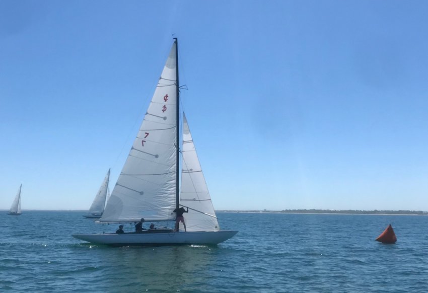 The Nantucket High School boat rounds the windward mark in the first race ahead of the fleet in Saturday&rsquo;s Nantucket Yacht Club IOD June Invitational.