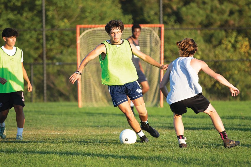 Treyce Brannigan takes on a challenge from defender Dylan Bell at boys soccer practice.
