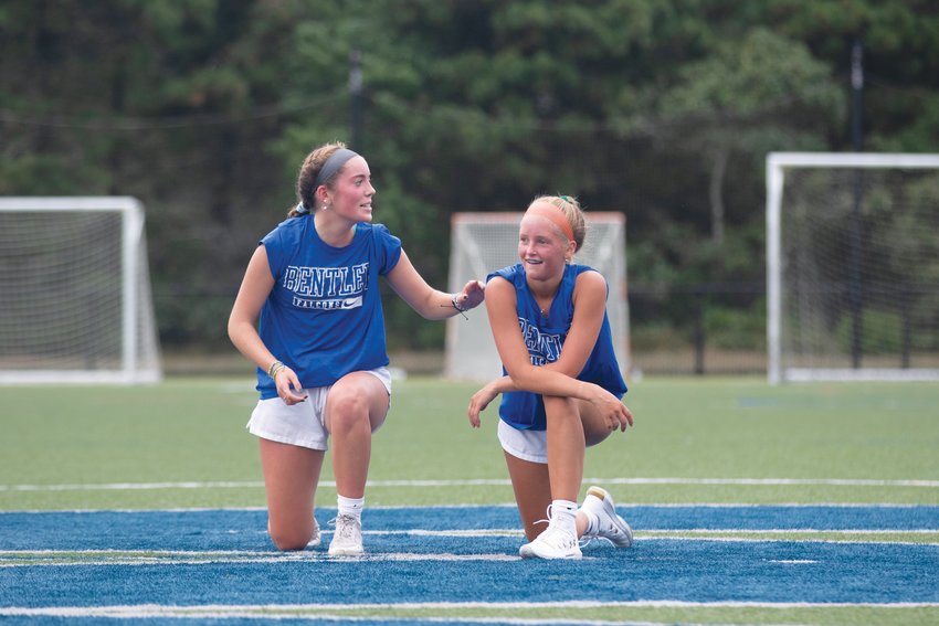 Adney Brannigan and Gianna Quinn take a knee at midfield during preseason practice.