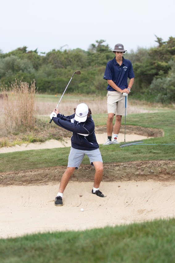Cole Chambers hits out the bunker against Nauset Monday while his teammate Henry Kathawala looks on.