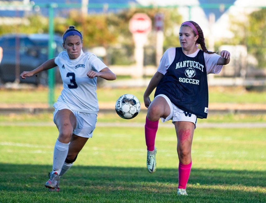 Chelsea Gross clears the ball as a defender closes in.