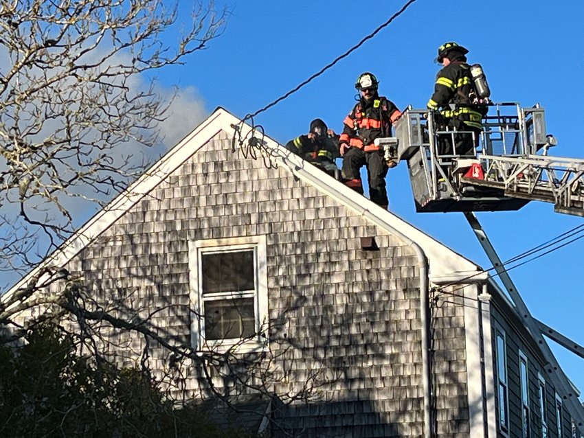 Firefighters on the roof of 32 Vestal St. Monday morning.