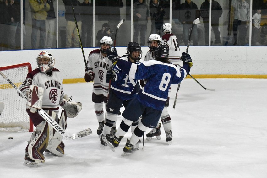 Curren Hatch (8) and Canton Jenkinson celebrate after Jenkinson's first period goal during the Whalers' 4-2 win Saturday over Bishop Stang.