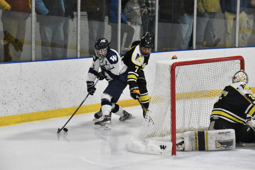 Jack Billings battles for the puck behind the Nauset net during Monday's game.