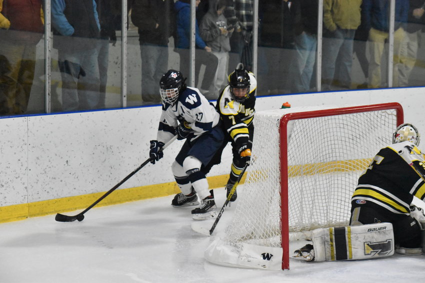 Jack Billings carries the puck behind the Nauset net and skates around a defender during the Whalers&rsquo; 4-1 loss at home Monday.