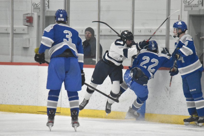 Ryan Davis hits an Auburn/Millbury player during Monday's opening round game of the Jeff Hayes Memorial Hockey Tournament at Gallo Arena in Bourne.
