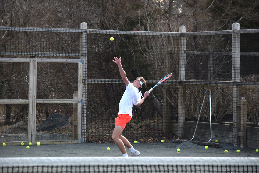 Quinn Keating lines up a serve at boys tennis practice Monday.