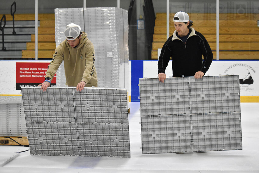 Jack Billings, left, and Will Datillo at work Monday morning installing the new dry floor system at Nantucket Ice. The rink is holding an open house Wednesday from 6 p.m. to 9 p.m. to showcase the new floor.