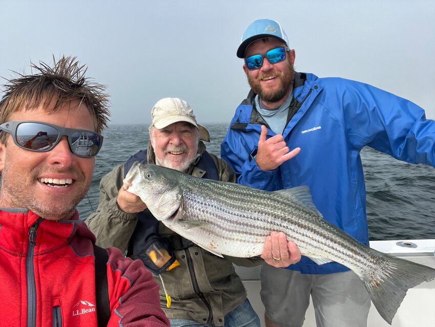 Capt. Corey Gammill, Dave Policansky and Chris Cothran with a bass in the rip east of Nantucket.