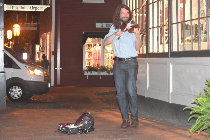 Busker Bobby Maguire plays the fiddle on Main Street in front of the Ralph Lauren store most nights during the summer season.