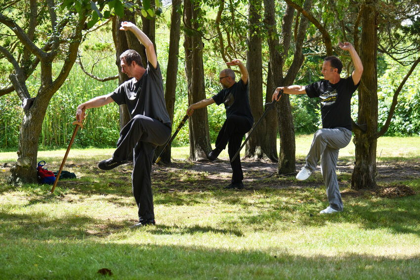 Members of the Xiuwen martial arts group practice Chinese internal martial arts every Sunday in Lily Pond Park. From left, Kris Feeney, Andy Buccino and Gerry Holmes perform &ldquo;probe the sea.&rdquo;