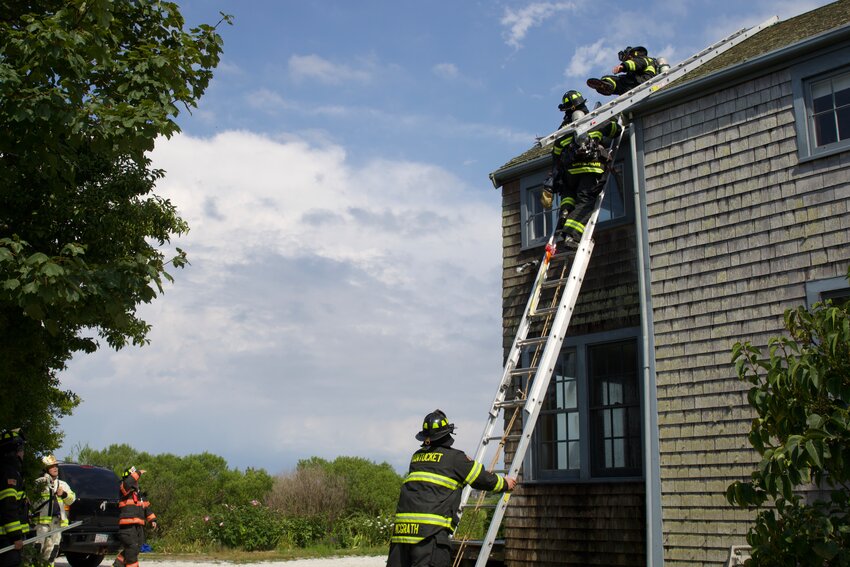 Firefighters on the roof of a Goose Pond Lane home struck by lightning Sunday.