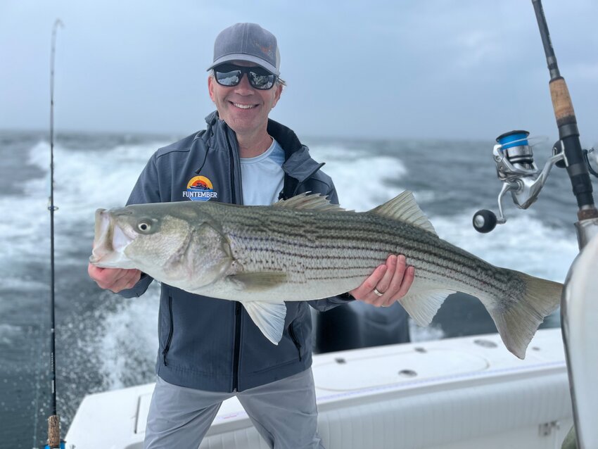 Michael Ruby with a big striped bass he caught from a boat this week.