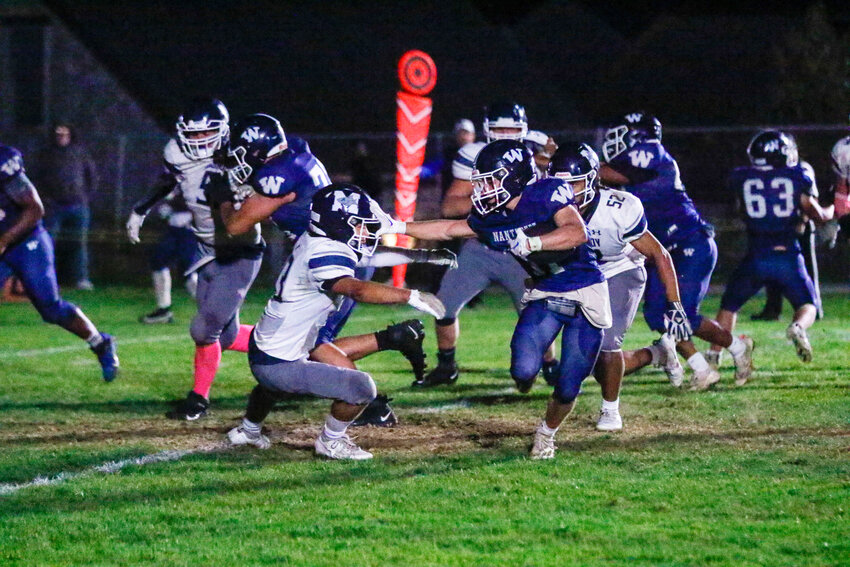 Arann Hanlon (11) stiff-arms a Monomoy defender during the Whalers&rsquo; 28-13 win last Thursday. The junior finished the game with three touchdowns.