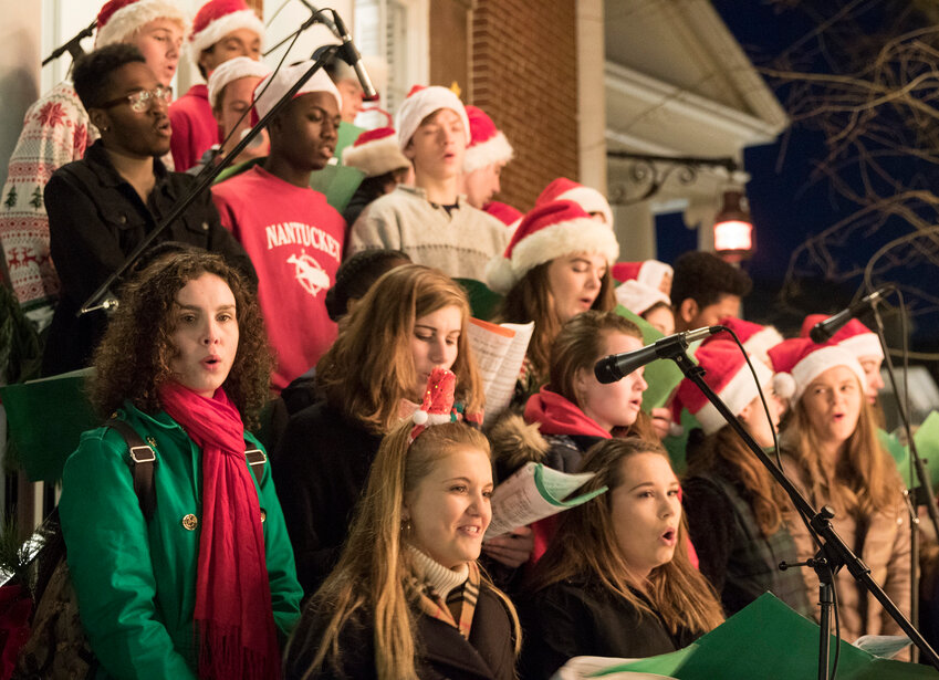 The Accidentals and Naturals, Nantucket High School&rsquo;s select choral groups, sing Christmas carols on the steps of Pacific Bank during the annual tree-lighting on Main Street.